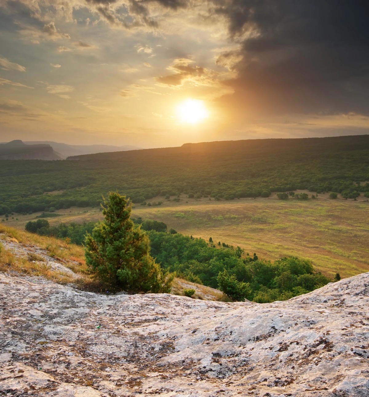Sunset over a mountain valley from a rocky outlook
